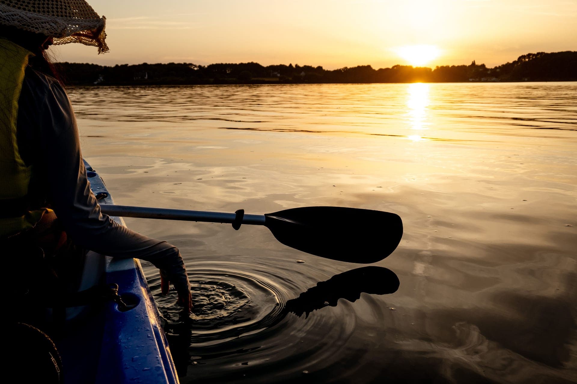 A kayak at sunset, reflected on a calm lake