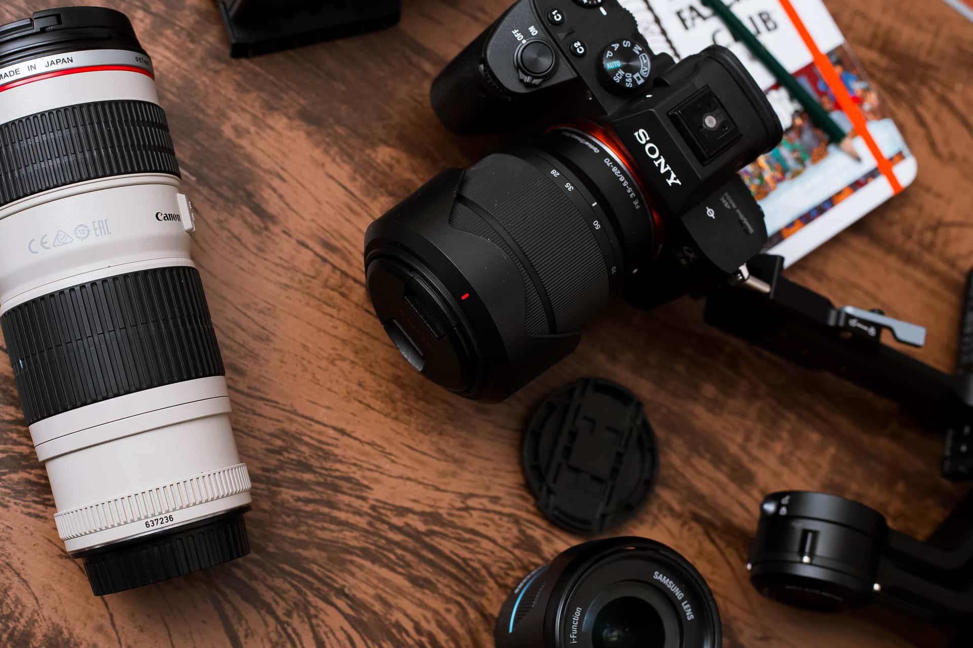 Camera lenses and equipment laid out on a wooden table