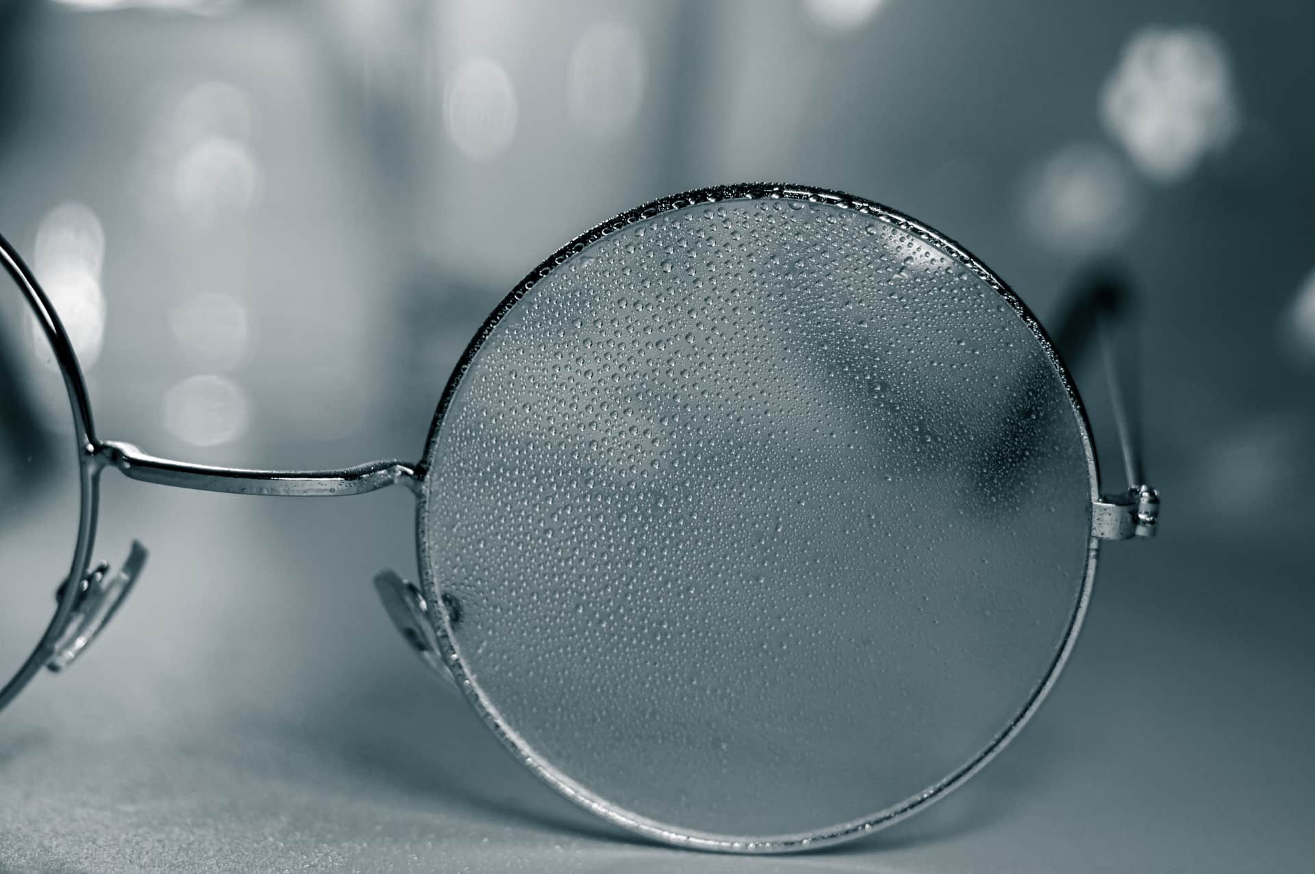 Raindrops beaded on a glass lens