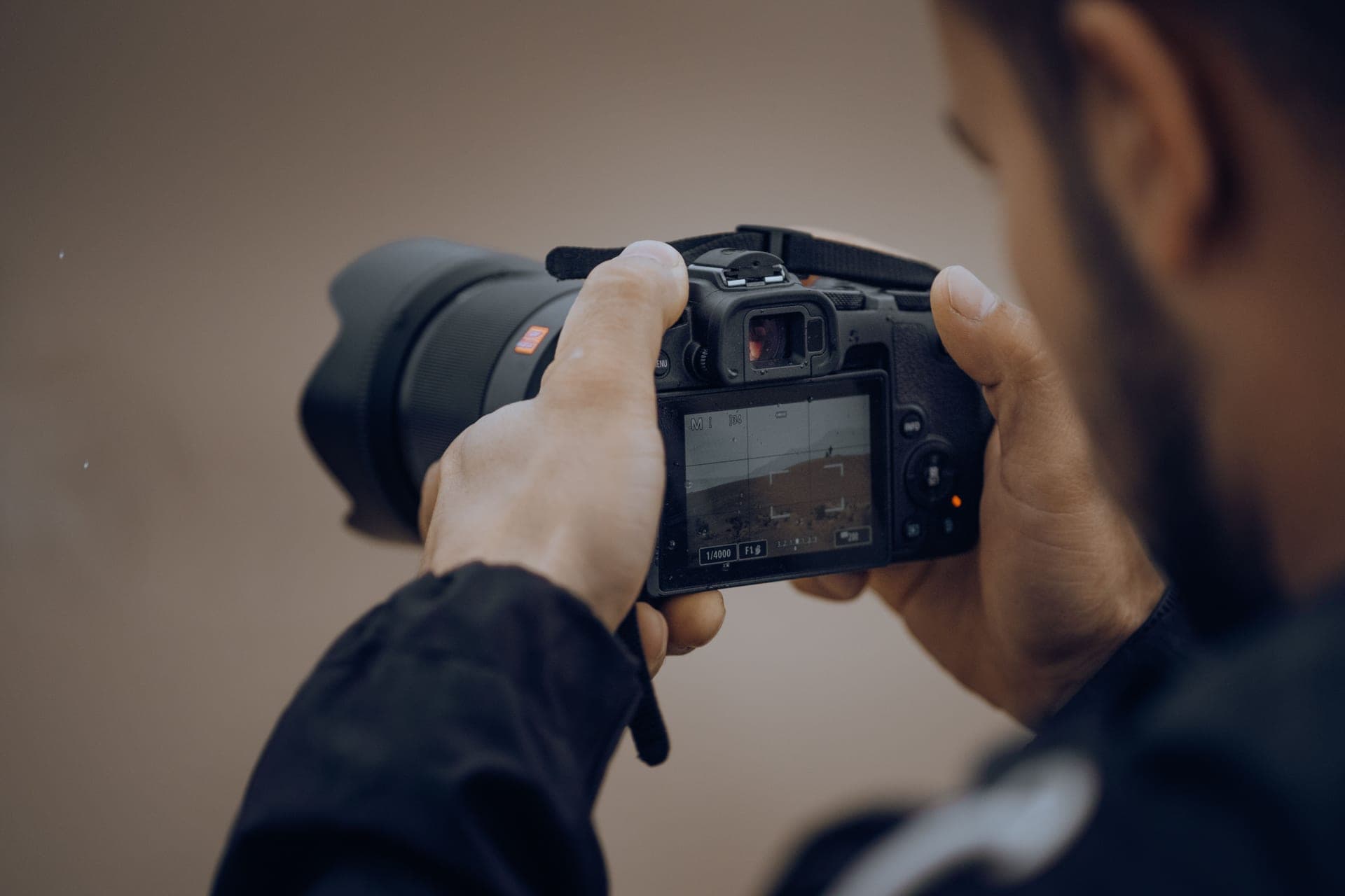 A photographer adjusting the settings on a camera outdoors
