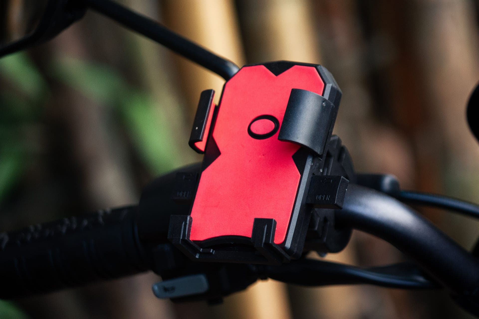 A red phone holder mounted on a bicycle handlebar