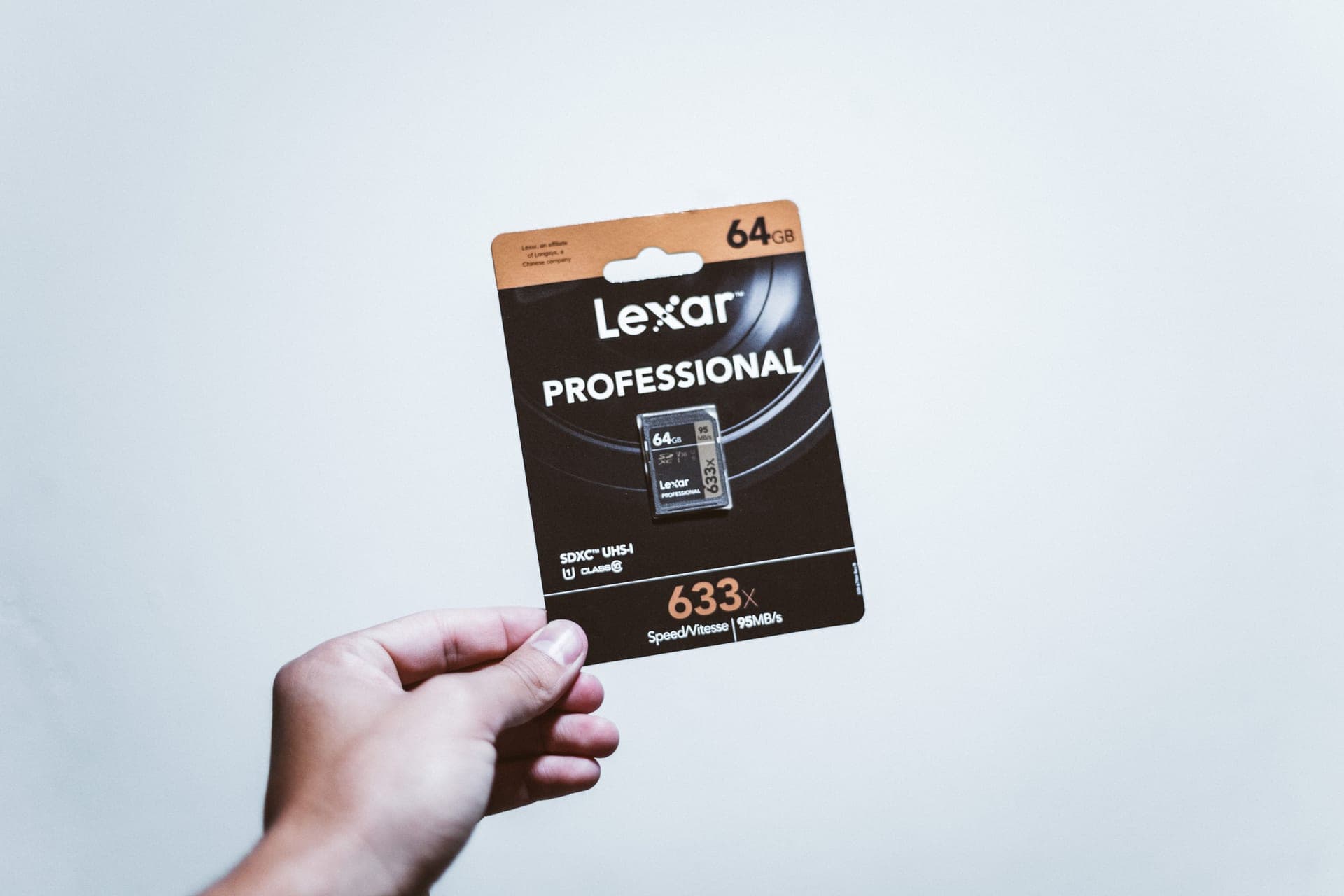 A hand holding a packaged SD card