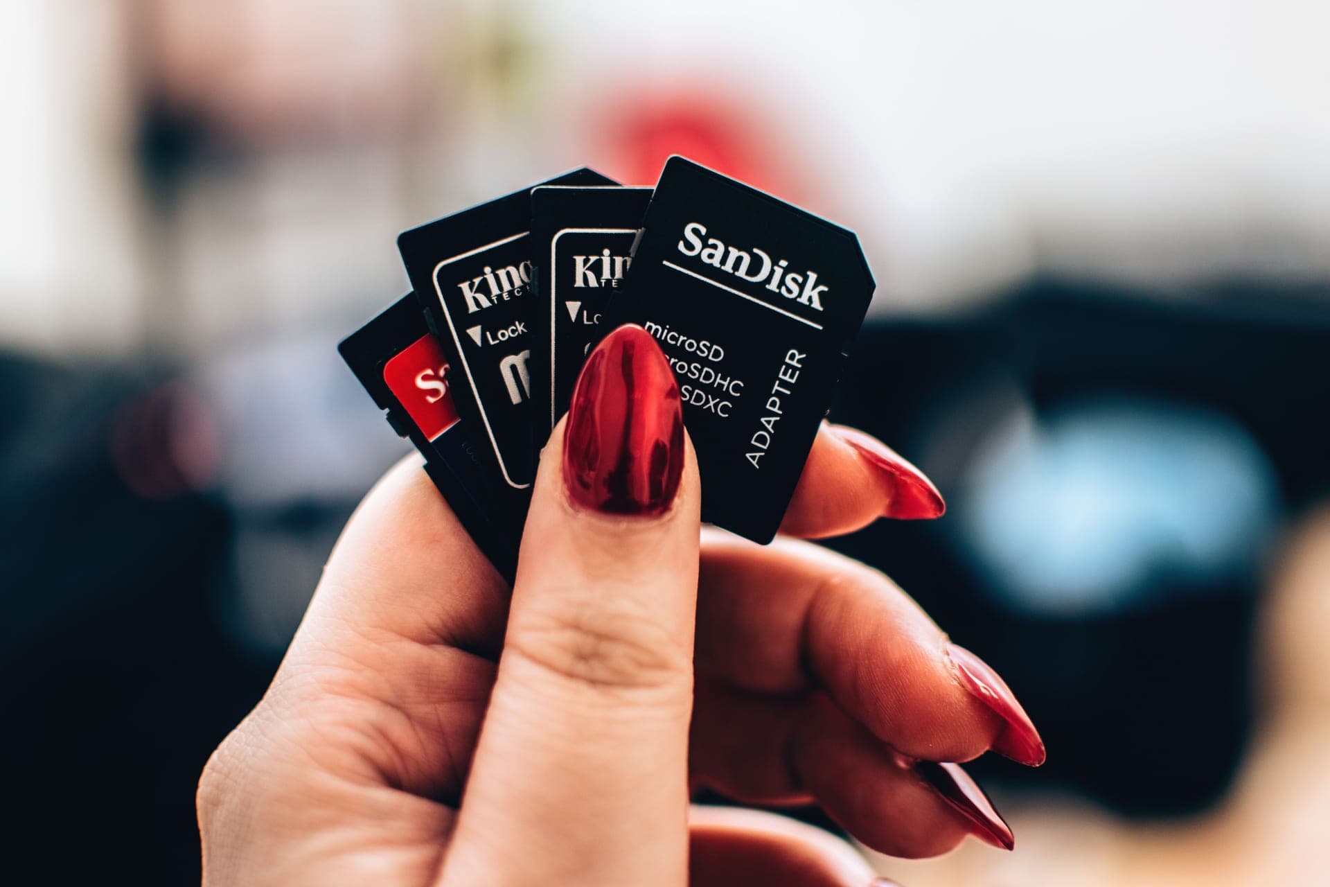 A hand holding several microSD memory cards